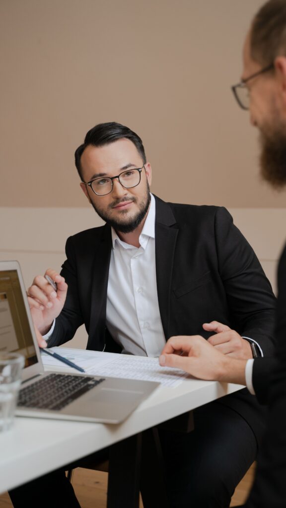 pexels photo 5520284 5520284 Two businessmen in a meeting discussing strategies with laptops and documents.